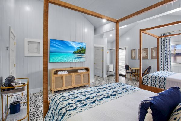 A cozy bedroom with a canopy bed, patterned floor, wall-mounted TV, and decorative accents creating a relaxing atmosphere.